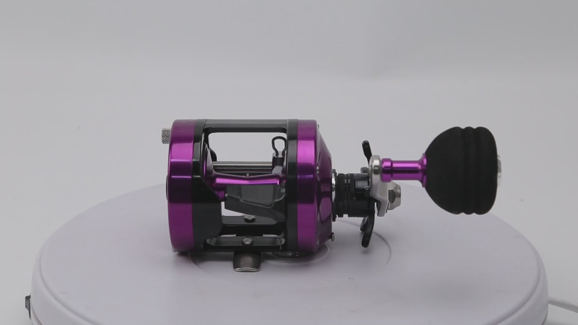 Topline YH001 purple casting reel attached to rod – ideal for jigging, ocean rock, and stream fishing