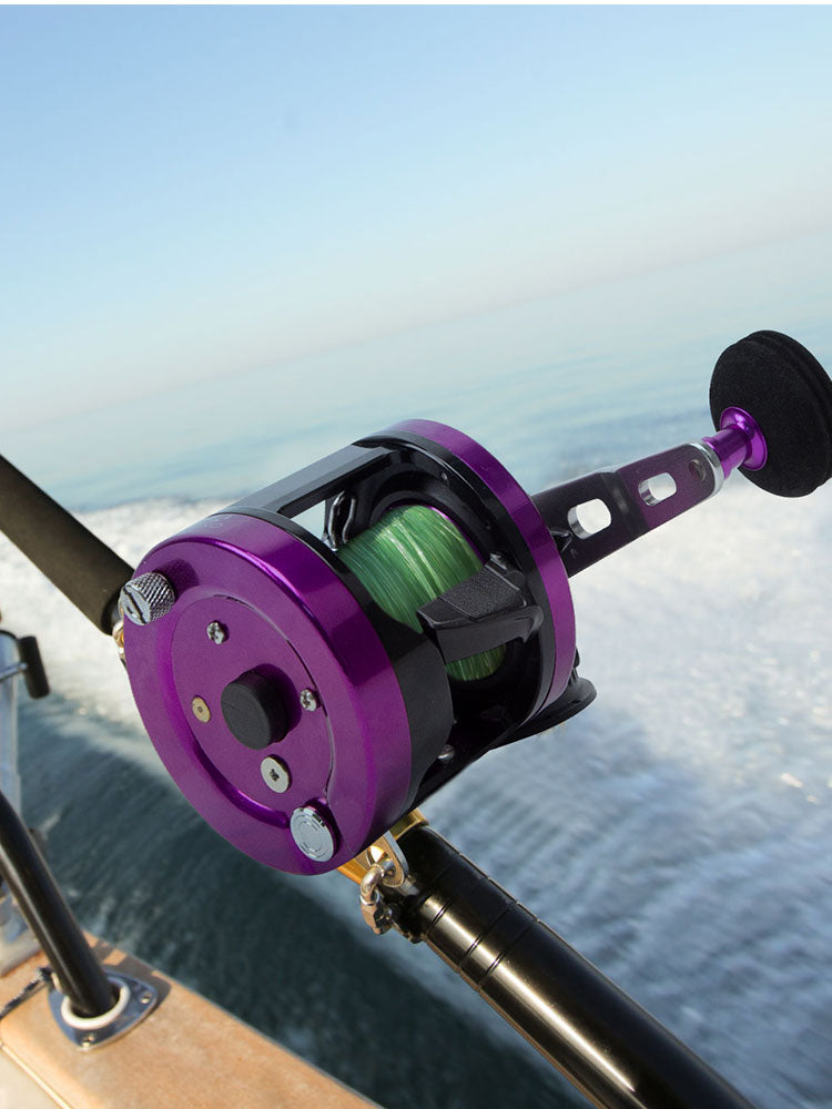 Topline YH001 purple casting reel attached to rod – ideal for jigging, ocean rock, and stream fishing

